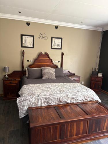 a bedroom with a large bed with a wooden headboard at Cloete Self Catering Sky Room in Ermelo