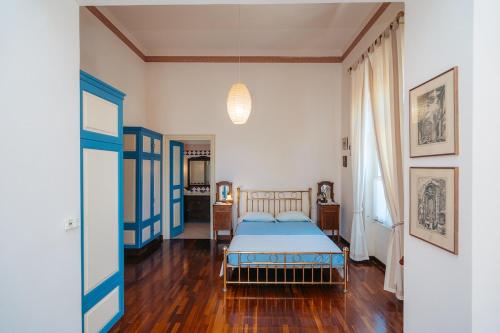 a bedroom with a blue bed in a room at Captain's Mansion Exampela in Apollonia