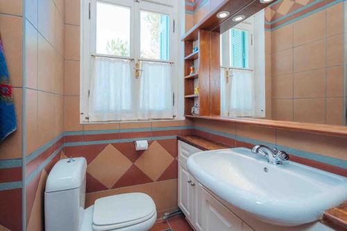 a bathroom with a sink and a toilet and a window at Captain's Mansion Exampela in Apollonia