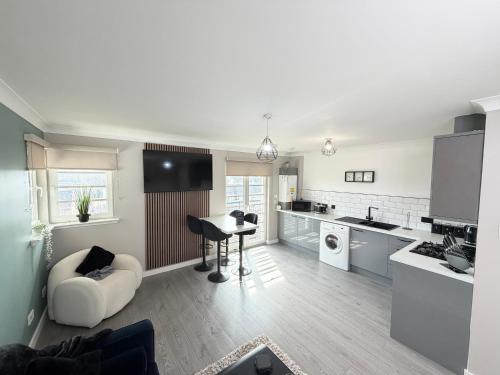 a kitchen and living room with a couch and a table at Bathgate Penthouse near Edinburgh in Bathgate