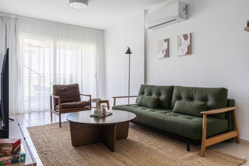a living room with a green couch and a table at Penthouse Apartment with Amazing View in Kiti in Kiti