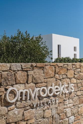 a stone wall with a sign on a building at Omvrodektis Village in Mykonos Airport
