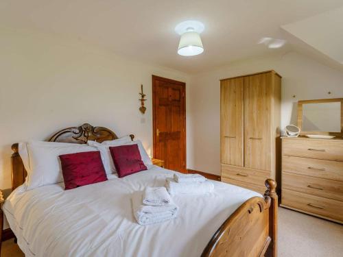 a bedroom with a large white bed with red pillows at 3 Bed in Penrith oc-90990 in Pooley Bridge