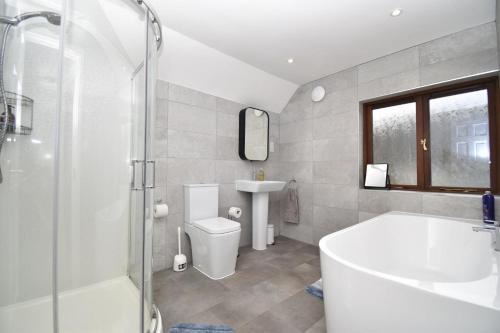 a bathroom with a tub and a toilet and a sink at 3 Bed in Penrith oc-90990 in Pooley Bridge