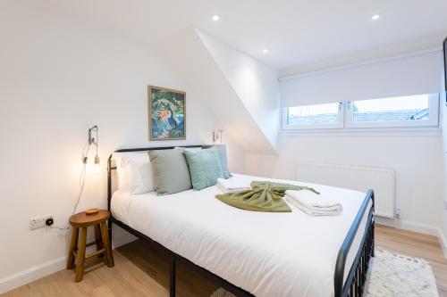 a bedroom with a large white bed with a window at The Pinkish House - 4 bed home in the town centre in Blairgowrie