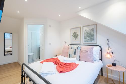 a bedroom with a bed with white sheets and pink pillows at The Pinkish House - 4 bed home in the town centre in Blairgowrie