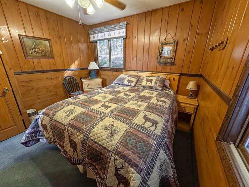 a bedroom with a bed in a wooden room at Bayside - Bouchard Shores Resort in Minocqua