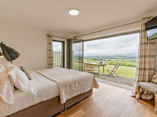 a bedroom with a bed and a large window at 2 Bed in Forfar oc-92623 in Aberlemno