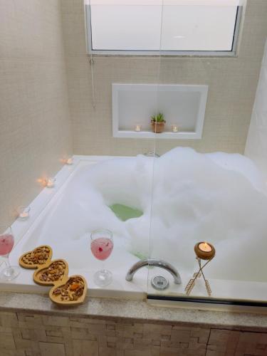 a bath tub with glasses of wine and cookies in it at Deruci Chale in Nova Friburgo