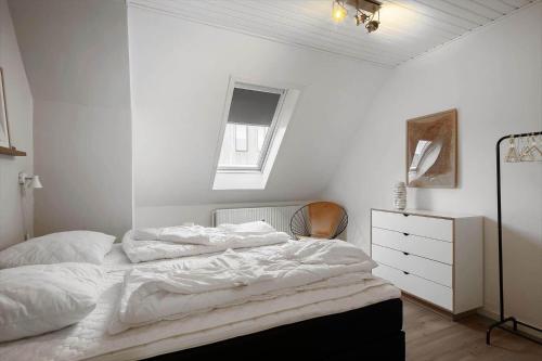 a white bedroom with a bed and a dresser at 890-Hvide-Sande-Bredgade-3-B-1 in Hvide Sande