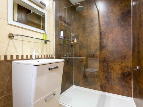 a bathroom with a shower and a toilet and a sink at 3 Bed in Penrith oc-sz299 in Pooley Bridge