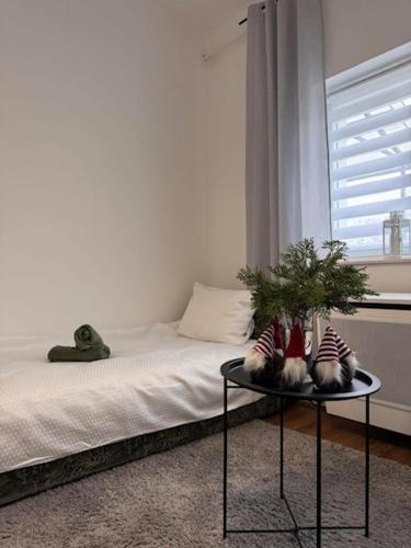 a bedroom with a bed and a table with pillows at Léda Vendégház in Vásárosnamény