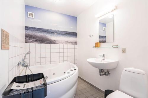 a bathroom with a bath tub and a sink at 733-Hvide-Sande-Slusen-33 in Hvide Sande
