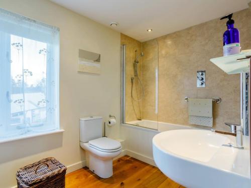a bathroom with a toilet and a sink and a shower at 2 Bed in Bridport oc-dc081 in Loders