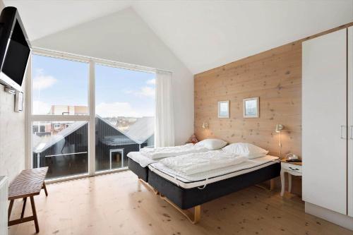 a bedroom with a bed and a large window at 727-Hvide-Sande-Slusen-27 in Hvide Sande