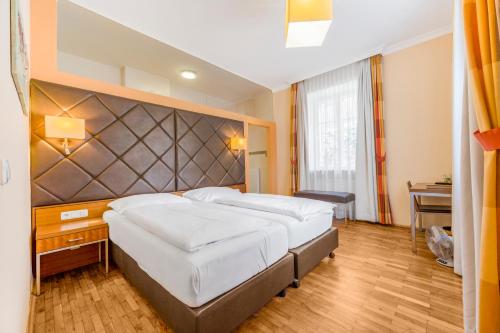 a bedroom with a large bed with a large headboard at Villa Ceconi by Das Grüne Hotel zur Post - 100% BIO in Salzburg