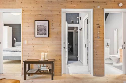 a bedroom with wooden walls and a room with a table at 701-Hvide-Sande-Slusen-1 in Hvide Sande