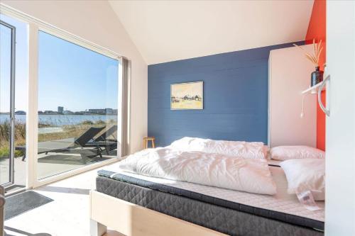 a bedroom with a bed and a large window at 705-Hvide-Sande-Slusen-5 in Hvide Sande