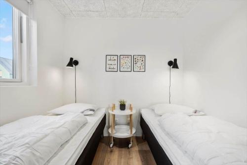 two beds in a room with a table and two lamps at 948-Hvide-Sande-Langsand-226 in Hvide Sande