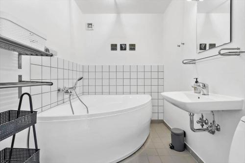 a white bathroom with a tub and a sink at 723-Hvide-Sande-Slusen-23 in Hvide Sande