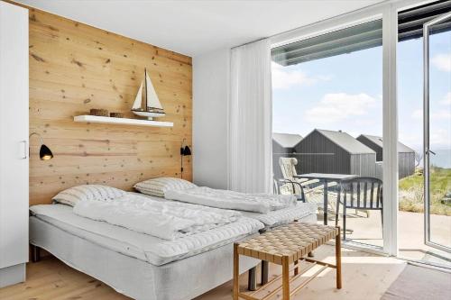 a bedroom with two beds and a balcony with a table at 723-Hvide-Sande-Slusen-23 in Hvide Sande