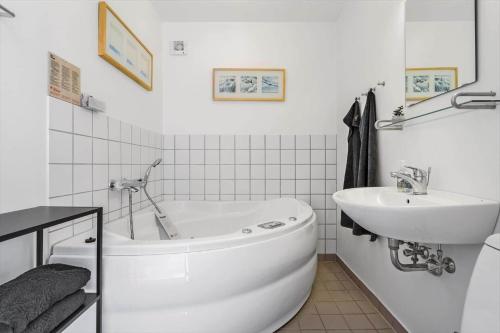 a white bathroom with a tub and a sink at 722-Hvide-Sande-Slusen-22 in Hvide Sande