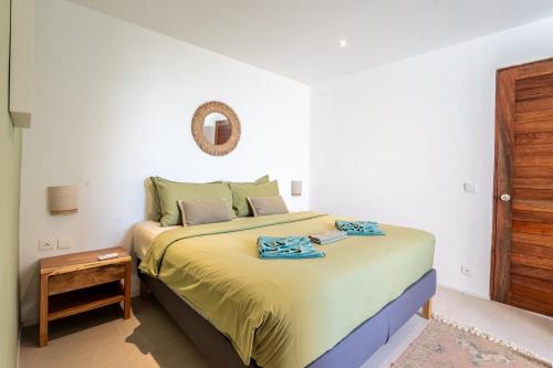 a bedroom with a bed and a mirror on the wall at Titine Apartment in Srithanu