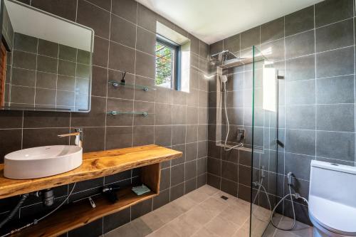 a bathroom with a sink and a shower at Titine Apartment in Srithanu