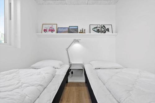 a bedroom with two beds and a desk with a lamp at 946-Hvide-Sande-Langsand-224 in Hvide Sande
