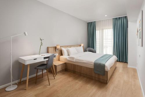 a bedroom with a bed and a desk and a table at Athina Suites Hotel in Bucharest