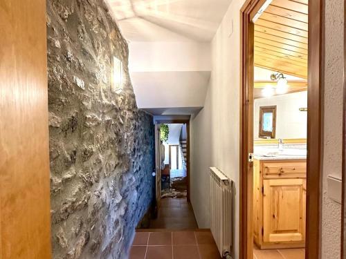 a hallway of a house with a stone wall at Cal Grit casa de muntanya a Pont de Bar in Bar