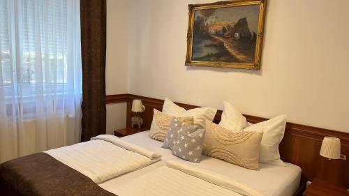 a bedroom with a bed with white sheets and pillows at Kőnig apartman in Hévíz