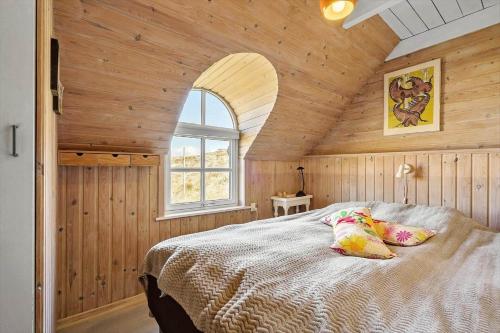 a bedroom with a bed in a wooden room at 505-Hvide-Sande-Riskrogvej-12 in Havrvig