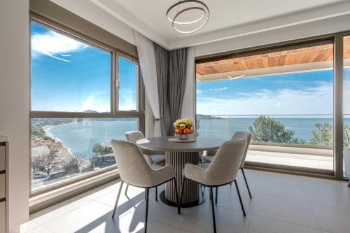 a dining room with a table and chairs and large windows at SeaLine Residence in Bar
