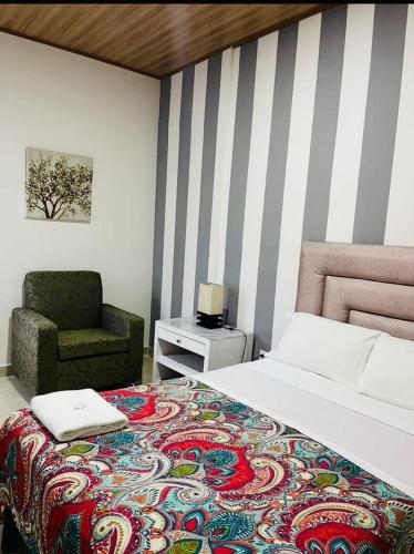 a bedroom with a large bed and a chair at Hostal Rio Piedra in Estelí