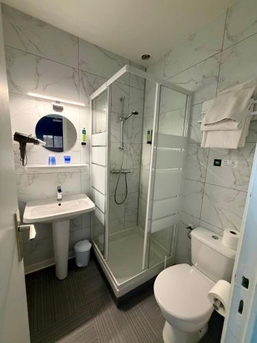 a bathroom with a shower and a toilet and a sink at La Marinière Hôtel Restaurant in Saint Malo
