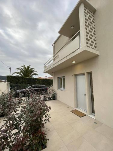 a white house with a balcony and a driveway at Brittos Home Lovely Stay - Villa Prime in Vila Nova de Famalicão