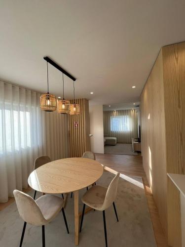 a dining room with a wooden table and chairs at Brittos Home Lovely Stay - Villa Prime in Vila Nova de Famalicão