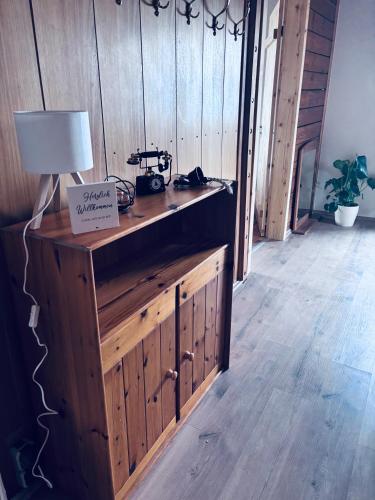 a room with a wooden wall with a table with a lamp at Ferienhaus am Reisberg in Reisberg