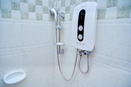 a shower with a phone on the wall of a bathroom at Sumni Hotel in Nkoanrua