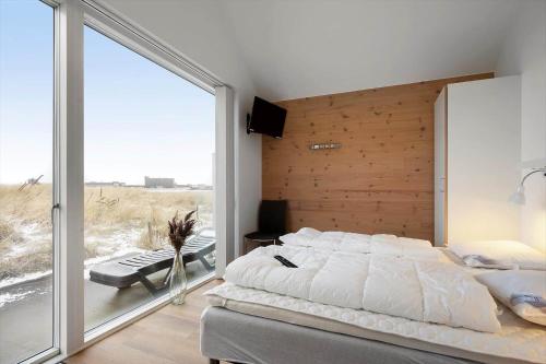 a bedroom with a bed and a large window at 745-Hvide-Sande-Slusen-45 in Hvide Sande