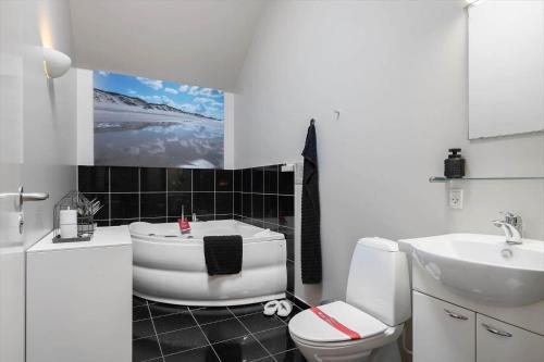 a bathroom with a tub and a toilet and a sink at 745-Hvide-Sande-Slusen-45 in Hvide Sande