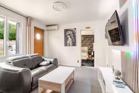 a living room with a couch and a table at Charme et confort in Valenton