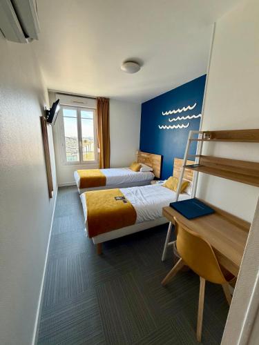 a hotel room with two beds and a desk at La Marinière Hôtel Restaurant in Saint Malo
