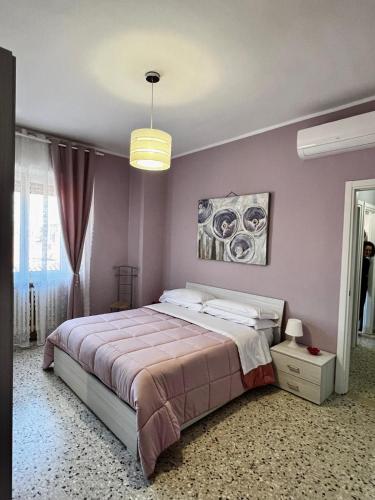 a bedroom with a large bed with purple walls at A due passi dalla Certosa in Certosa di Pavia
