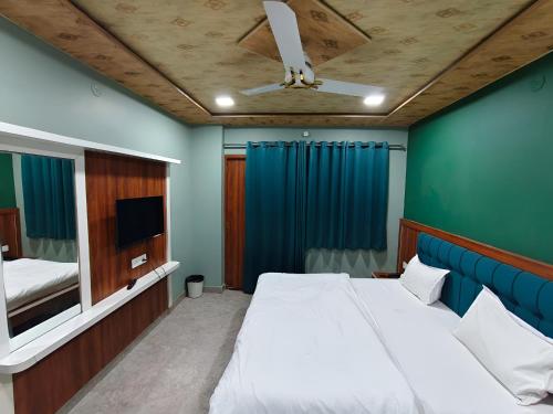 a bedroom with a large bed and a tv at Hotel Ajmer Pride in Ajmer