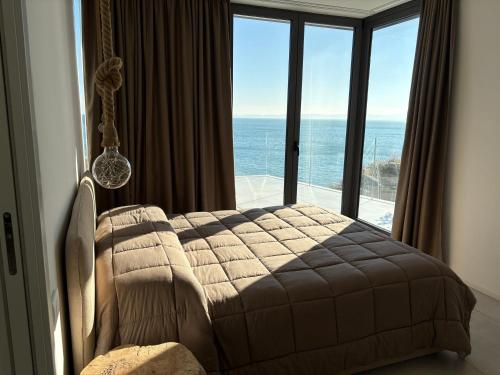 a bedroom with a bed and a view of the ocean at Seaside Resort in Santa Croce Mare