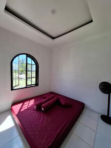 a red bed in a white room with a window at YouYouKe Pavillon Karangpapak in Cilauteureun
