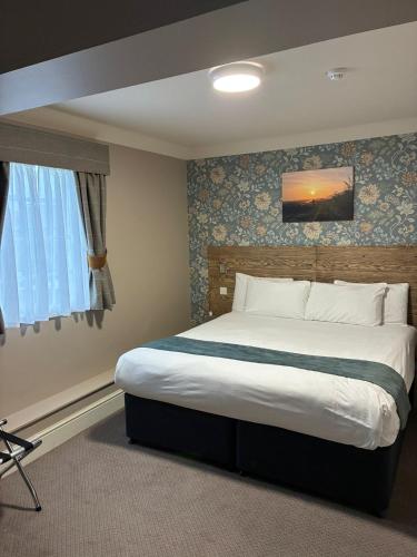 a bedroom with a large bed in a room at Ye Olde Griffin in March