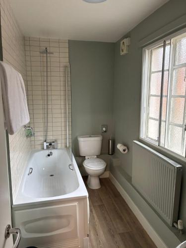 a bathroom with a white tub and a toilet at Ye Olde Griffin in March